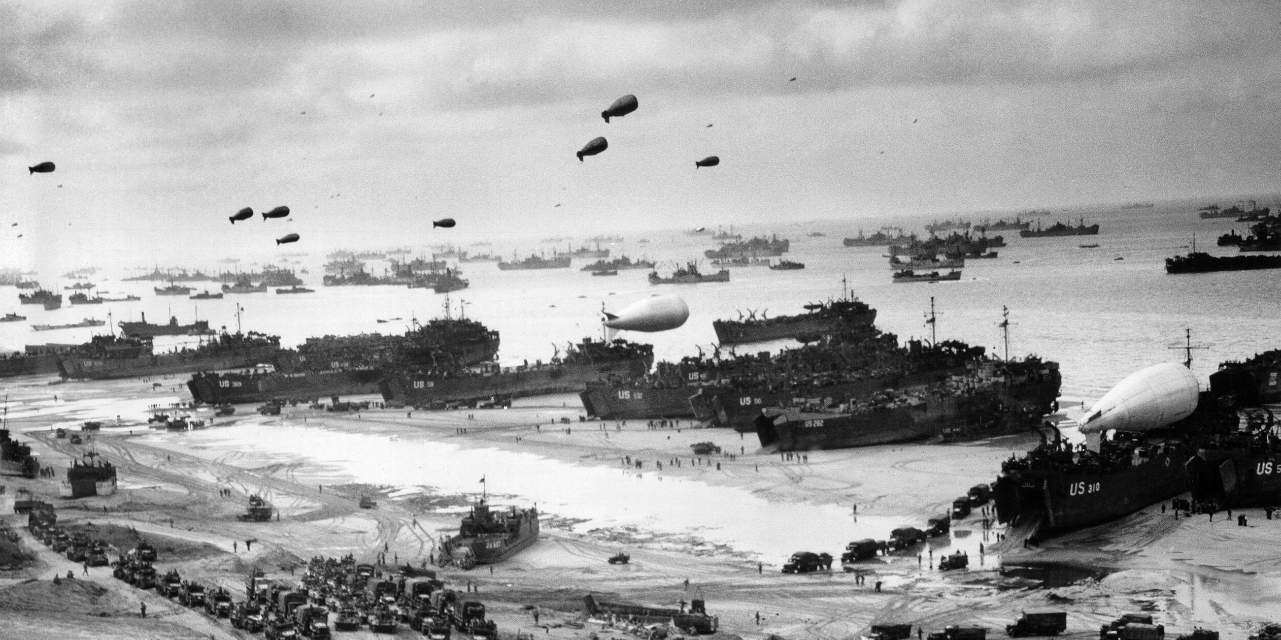 "Der Zweite Weltkrieg: Übermacht": Schwarz-Weiß-Aufnahme: Am Omaha Beach in der Normandie liegen zahlreiche Transportschiffe. Große Mengen Kriegsgerät werden entladen.