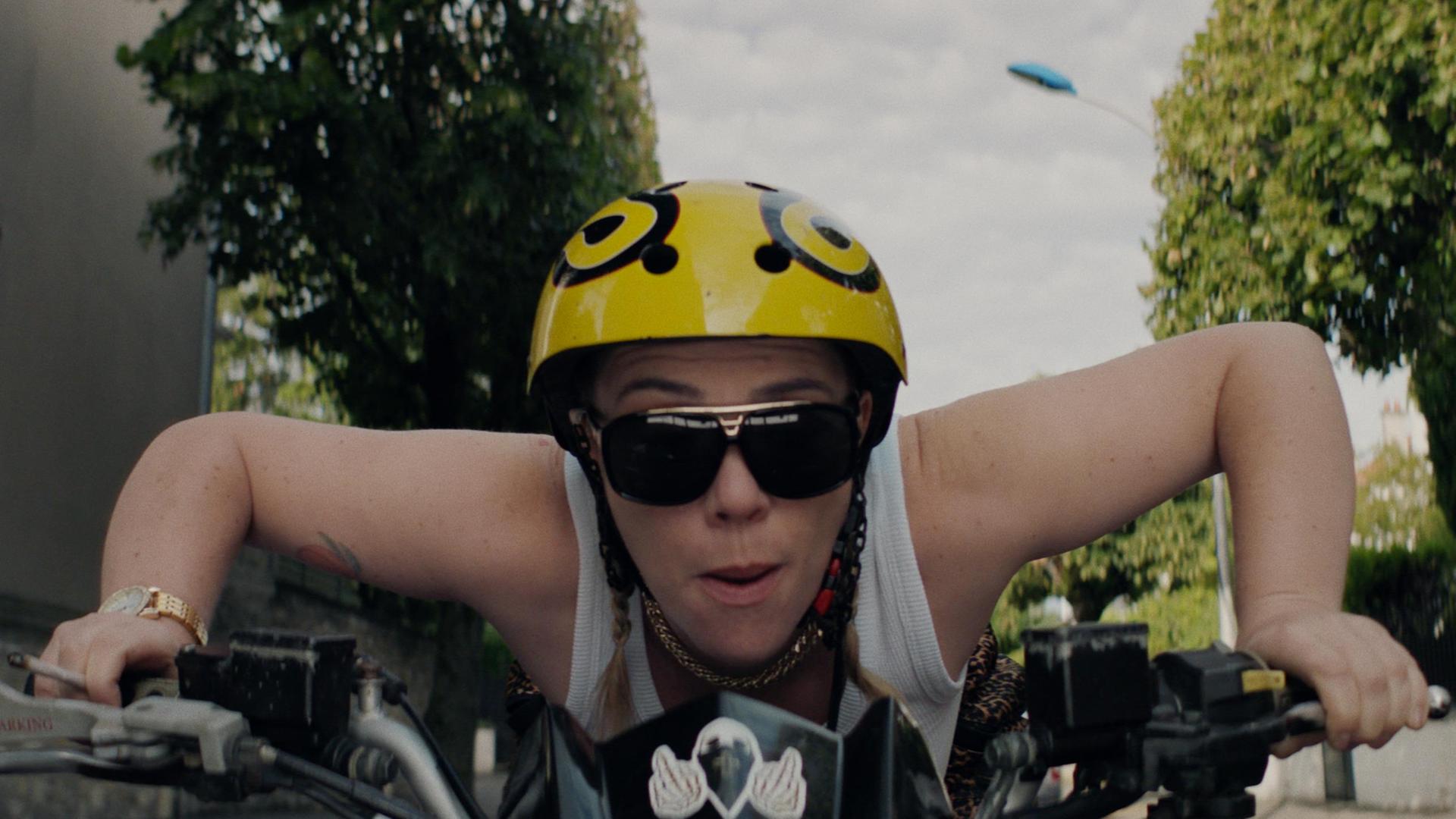 "Derby Girl": Eine Frau fährt auf einem Fahrrad. Sie trägt einen Helm und eine Sonnenbrille.