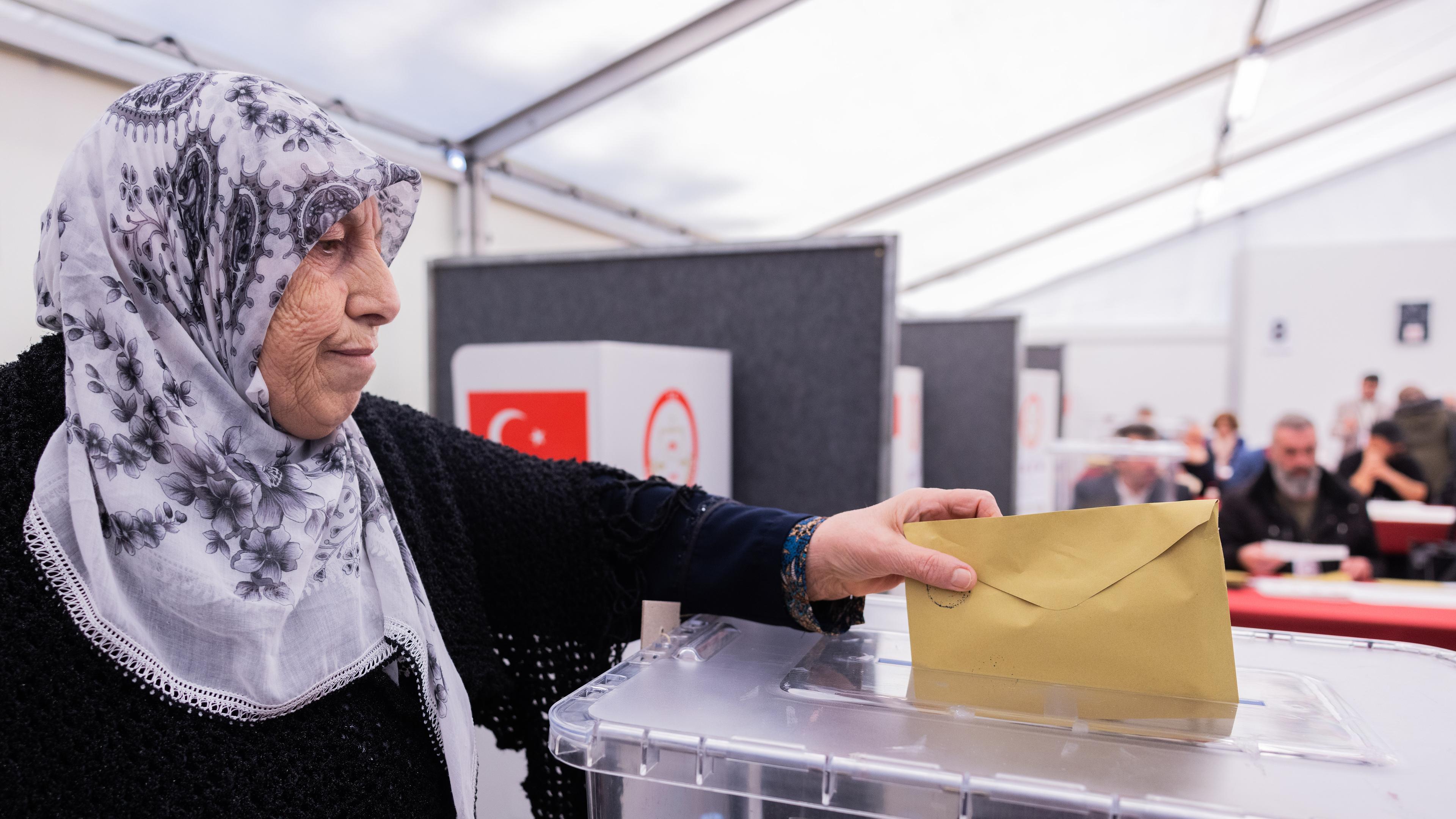 Ein Wählerin wirft im Türkischen Generalkonsulat seinen Stimmzettel für die Parlaments- und Präsidentenwahl in der Türkei in die versiegelte Wahlurne ein, aufgenommen am 27.04.2023