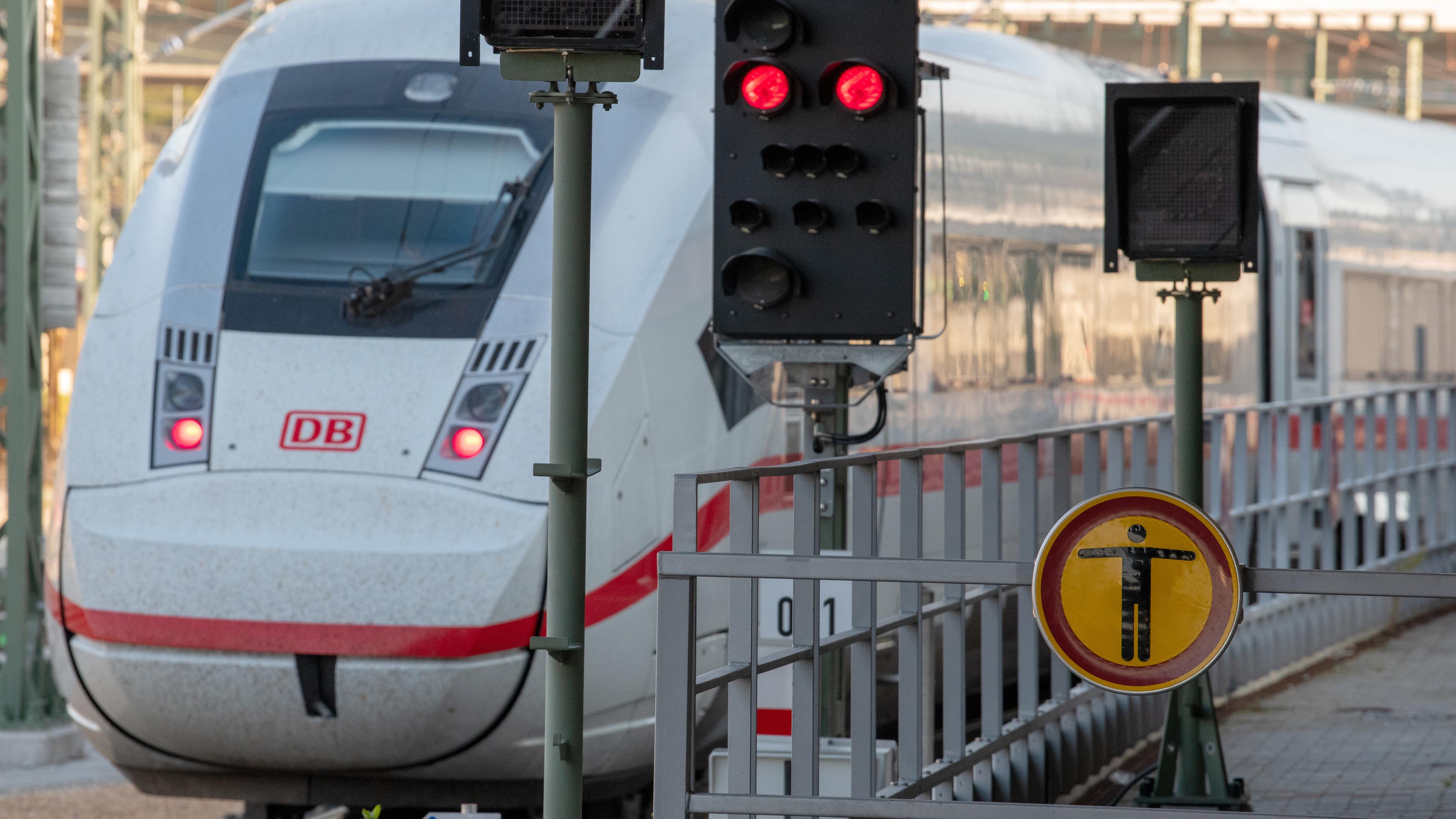 Im Hauptbahnhof fährt ein ICE der Deutschen Bahn an einem roten Signal vorbei. 