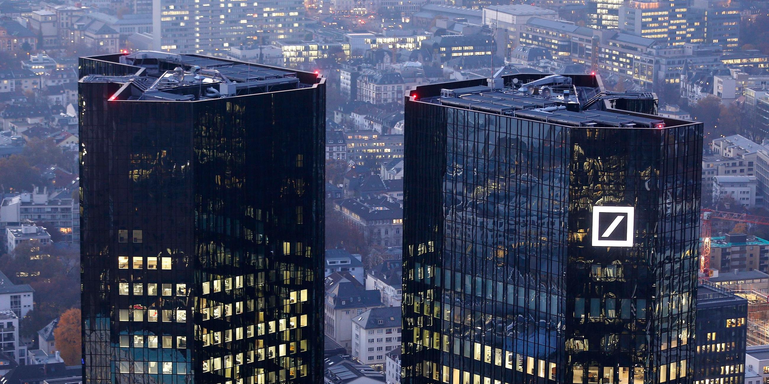 Zentrale der Deutschen Bank in Frankfurt, zwei hochhäuser im frühen Abendlicht.