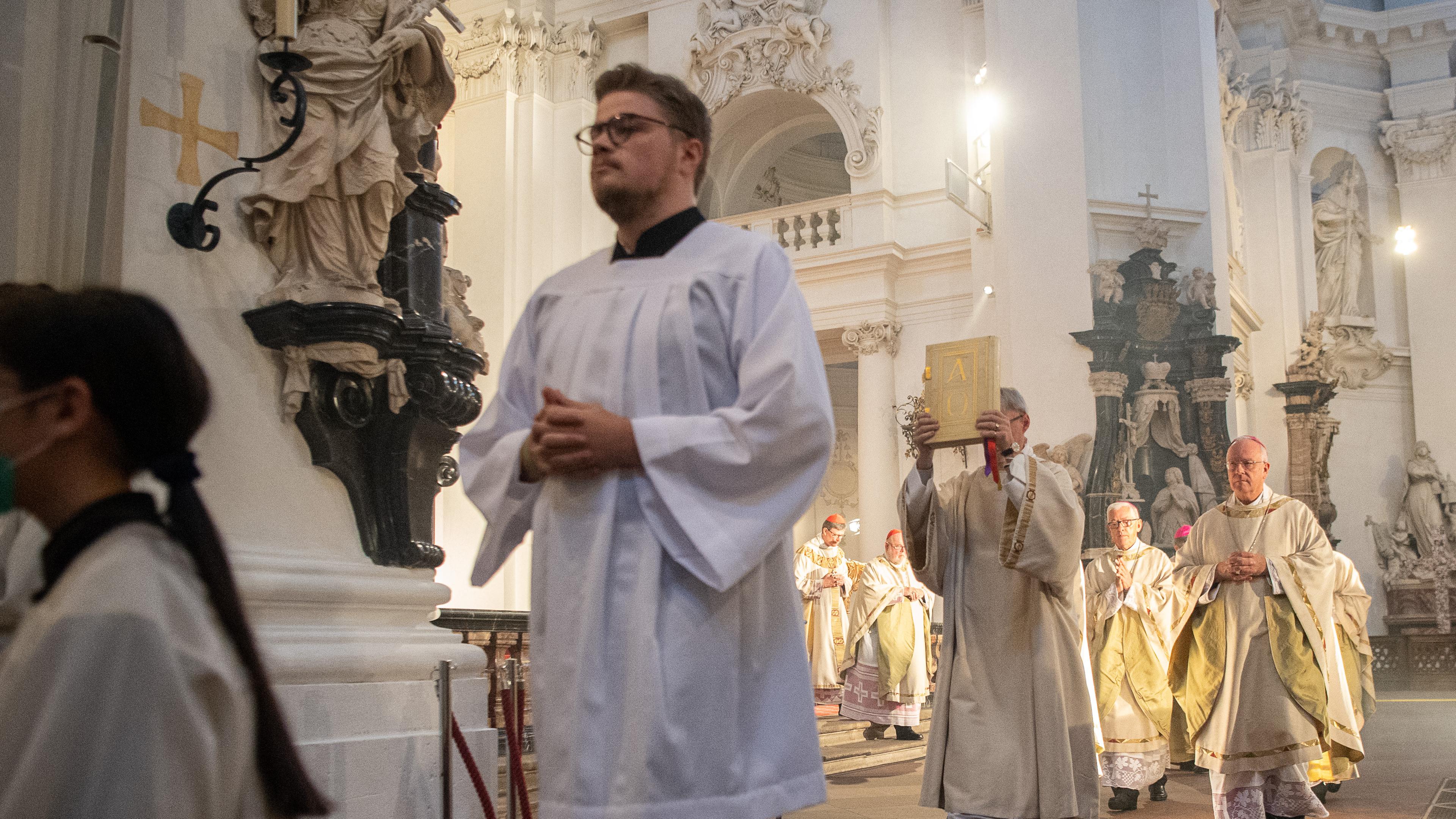 Bischöfe und Messdiener laufen durch einen Dom in Fulda