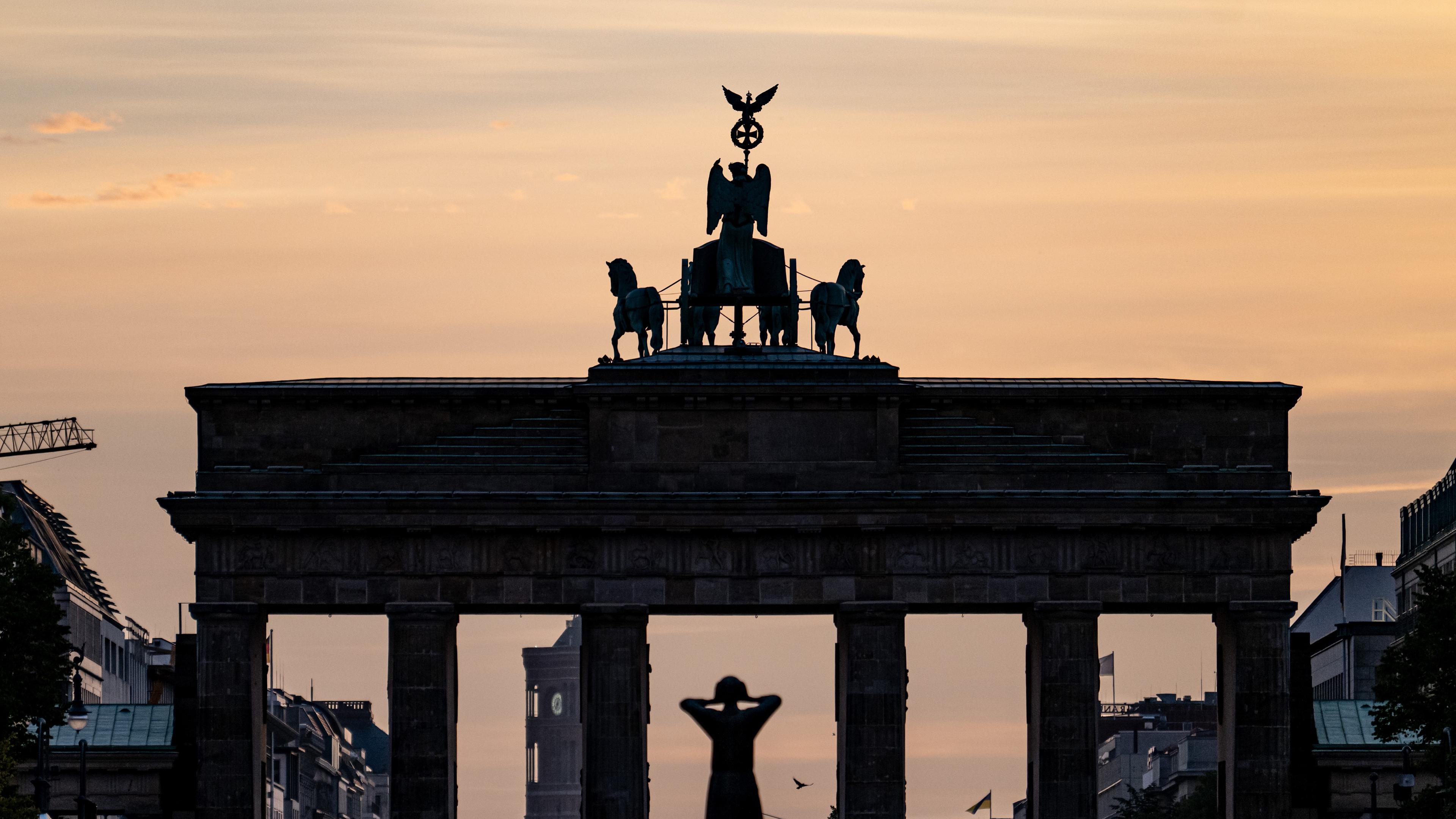 Das Brandenburger Tor in Berlin vom Sonnenaufgang beleuchtet.