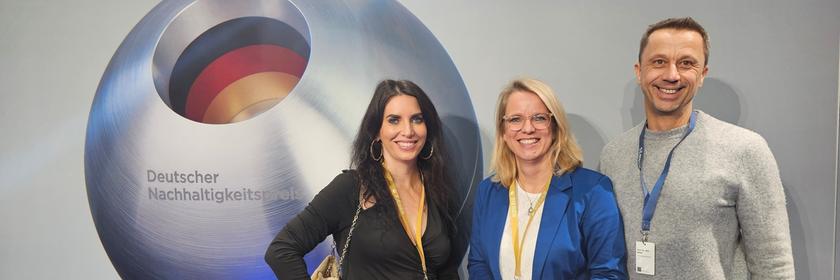 Das ZDF-Team für Nachhaltigkeit vor dem Logo des Deutschen Nachhaltigkeitspreises: Cristina Santos Couto, Tordis Koch und Jens Müller