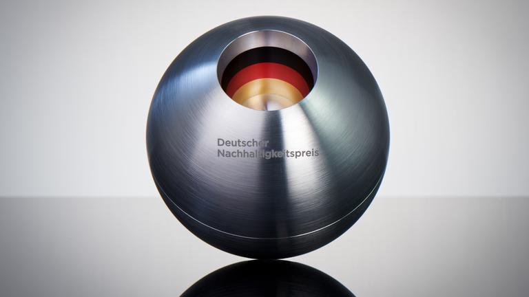 Der deutsche Nachhaltigkeitspreis: Eine Silberne Kugel mit dem eingravierten Schriftzug auf einem spiegelnden Untergrund
