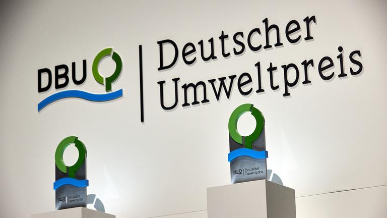 Zwei Trophäen, stehen vor Beginn der Verleihung des Deutschen Umweltpreises der Deutschen Bundesstiftung Umwelt (DBU) auf Podesten auf der Bühne.