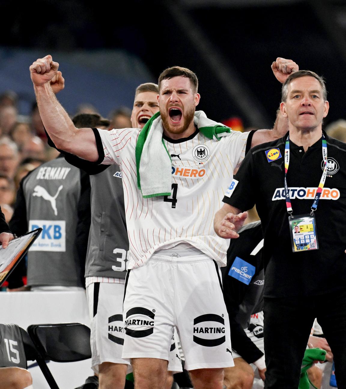 Deutschlands Johannes Golla (2.v.r.) jubelt während Bundestrainer Alfred Gislason (r) und Co-Trainer Erik Wudtke taktische Anweisungen geben.