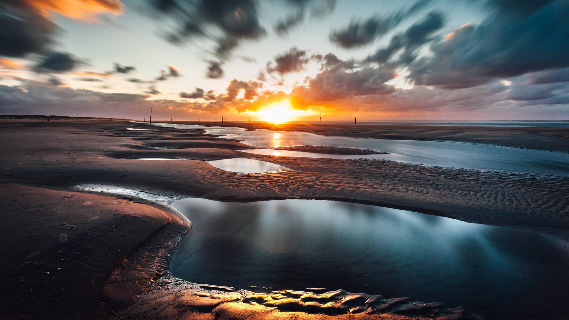 Sonnenuntergang im Wattenmeer Priele am Nordstrand von Norderney, Ostfriesland.
