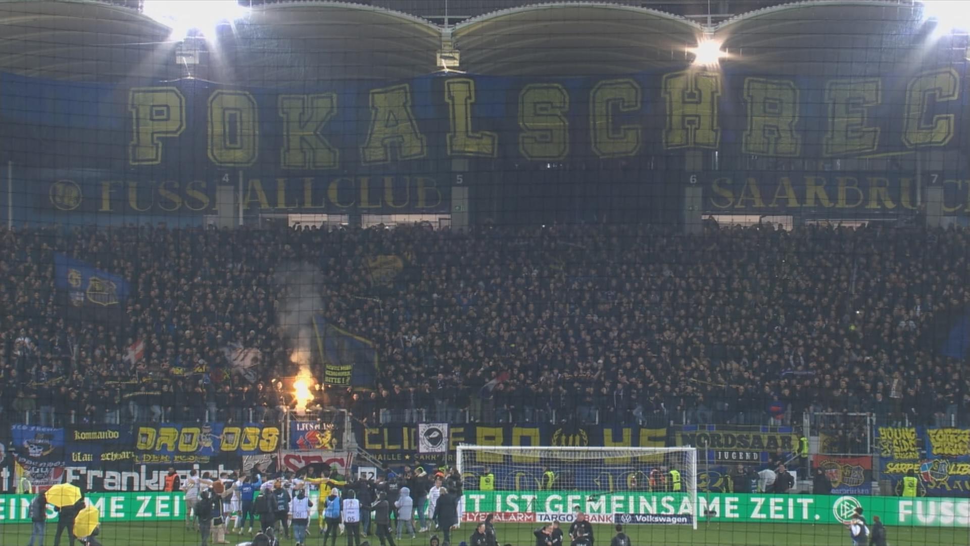 Fußballspiel Saarbrücken gegen Borussia Mönchengladbach im Stadion, Banner mit Aufschrift "Pokalschreck".