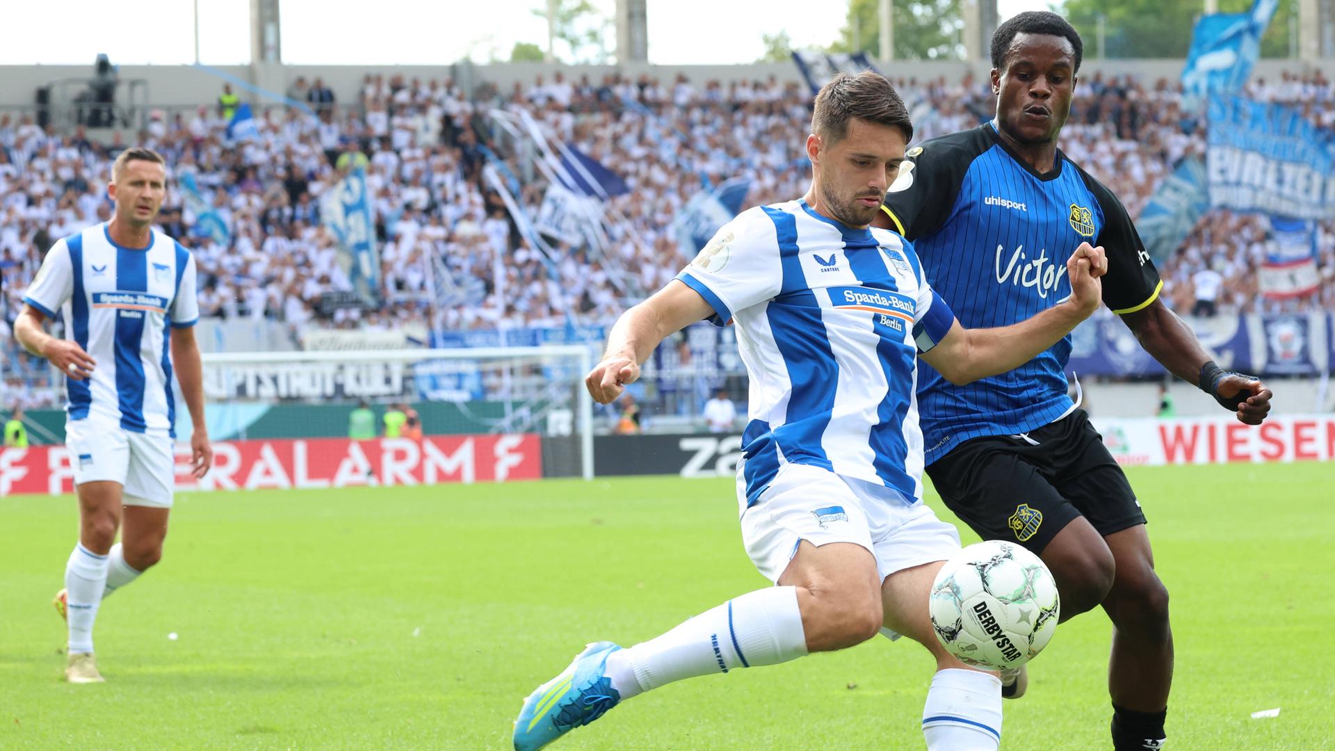 v.l. Josip Brekalo (Hertha BSC) und Abdenego Nankishi (1.FC Saarbruecken)  im Zweikampf am 22.08.2026 in Saarbrücken. 