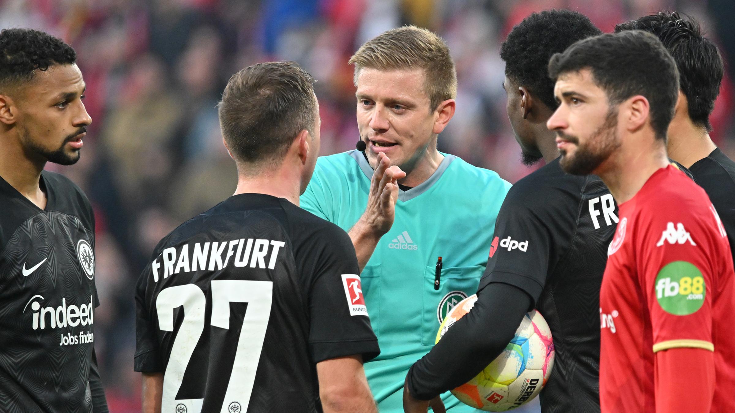 13.11.2022, Mainz: DFB-Schiedsrichter Robert Schröder diskutiert mit Frankfurts Mario Götze eine Elfmeterentscheidung