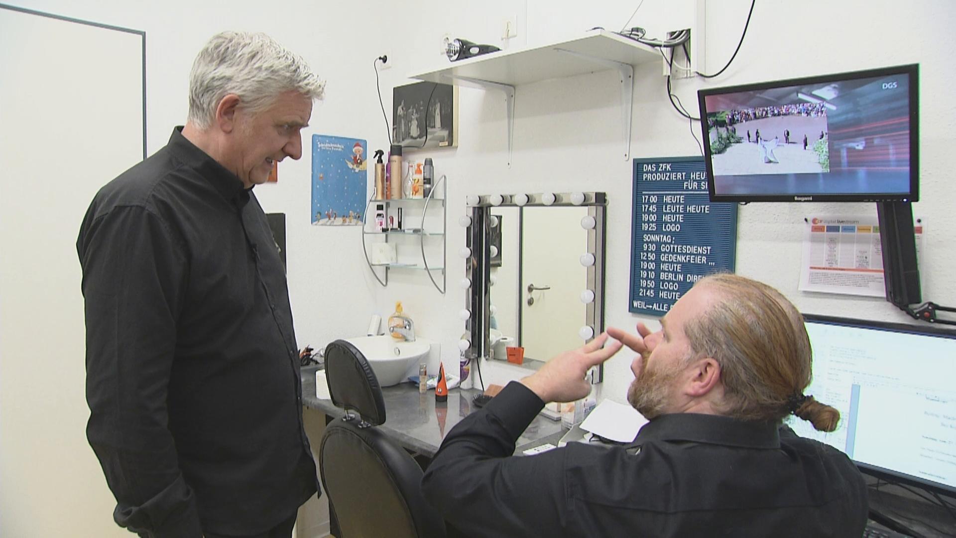 Die Gebärdensprachdolmetscher Uwe Schönfeld (links) und Mathias Schäfer besprechen die anstehenden Sendungen.