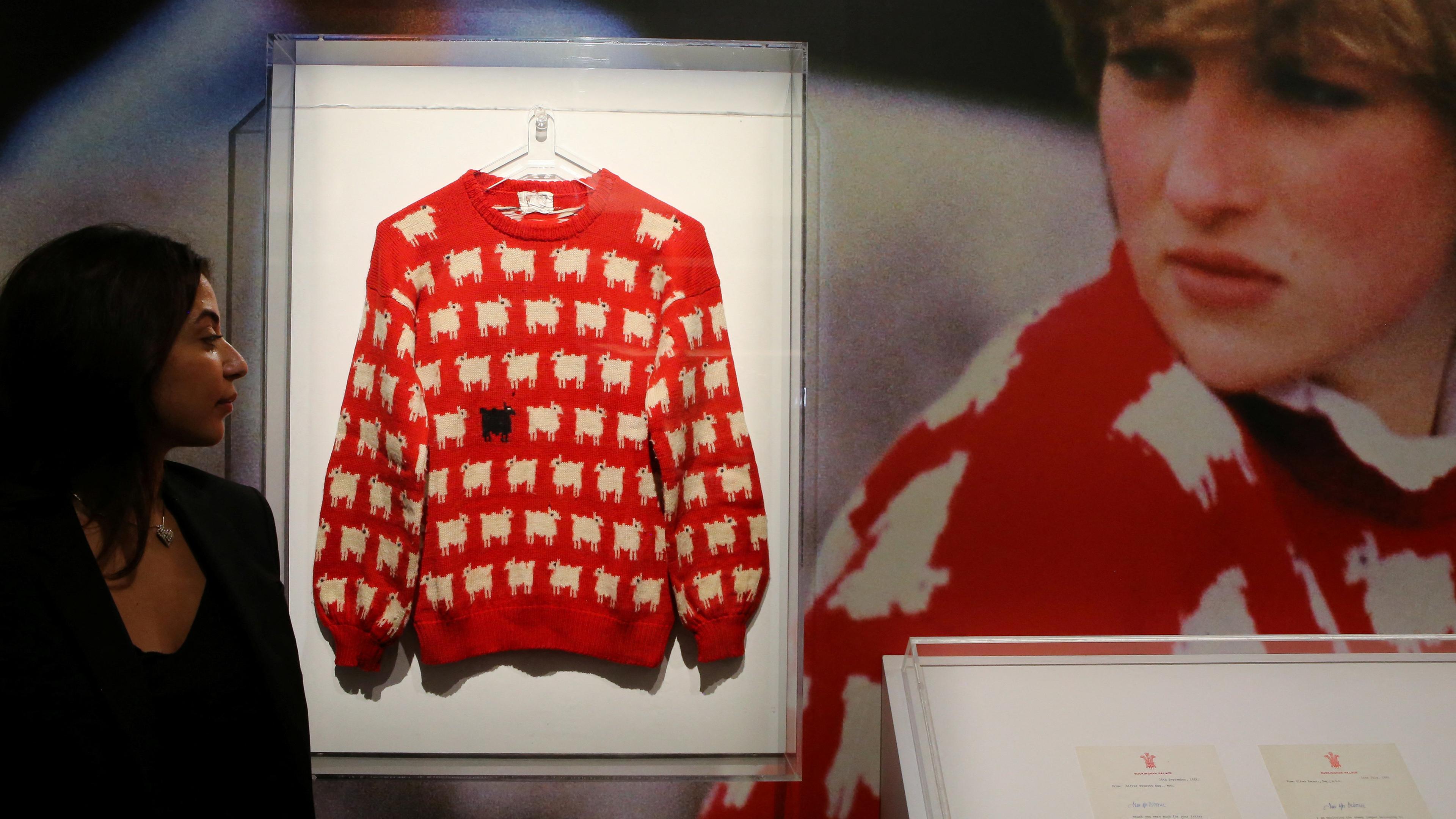 Der Pullover von Diana ist vor der Versteigerung neven einem Foto der Prizessin ausgestellt