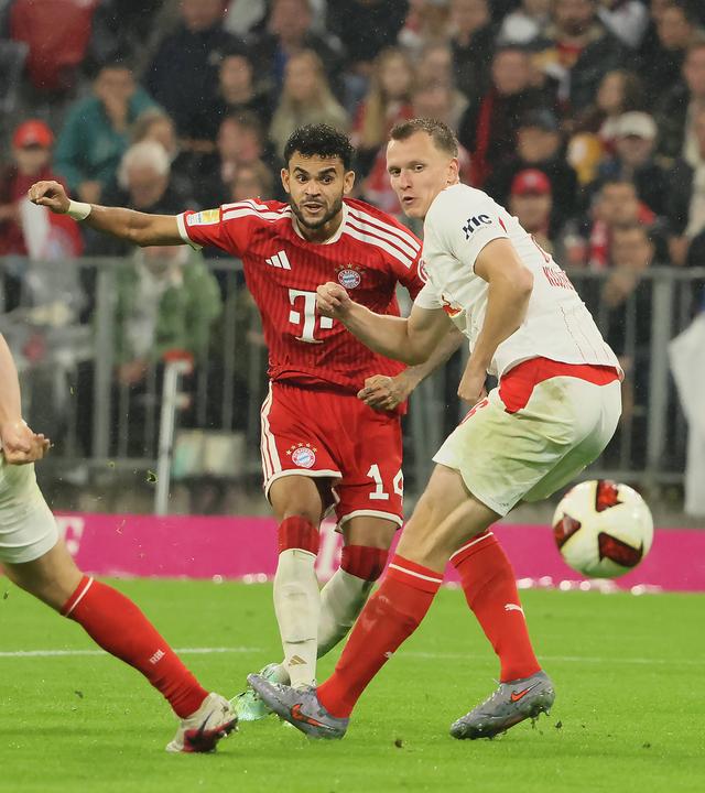 Bayerns Flügelspieler Luis Díaz schießt den Ball an seinem Gegenspieler Lukas Klostermann vorbei in Richtung des Tores
