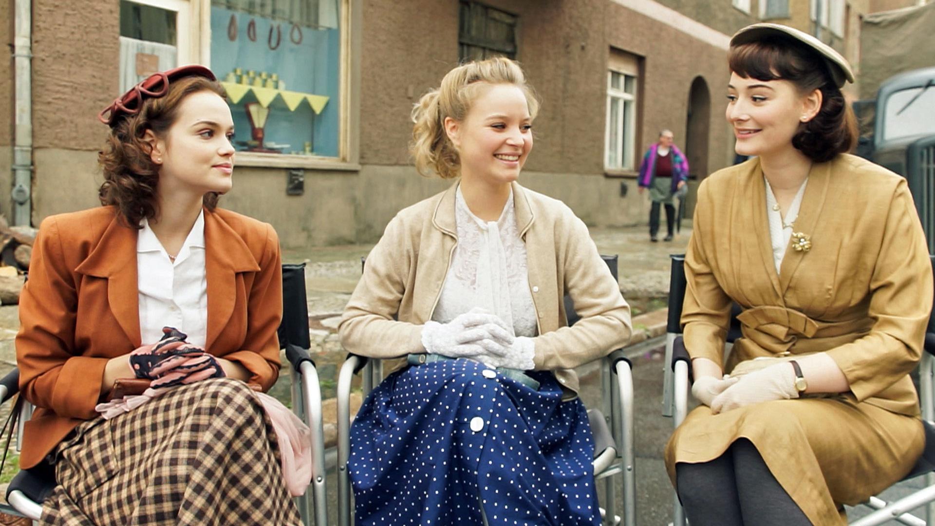 Die Darstellerinnen der Schöllack-Schwestern Emilia Schüle (l.), Sonja Gerhardt (m.) und Maria Ehrich (r.) im Interview. Sie sprechen über ihre Set-Erfahrungen, den Kleidungsstil der 1950er Jahre und über das Verhältnis zwischen Männern und Frauen zur damaligen Zeit.