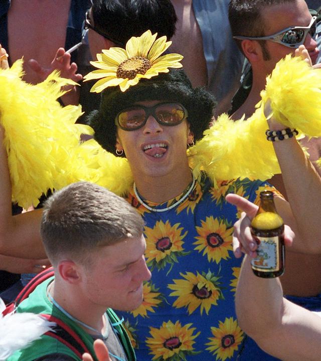 "Die 90er: 1993-1996: Loveparade und Börsenfieber": Mit Sonnenblumenschmuck und gelber Boa tanzt ein Raver bei der Love Parade in Berlin, 1999.
