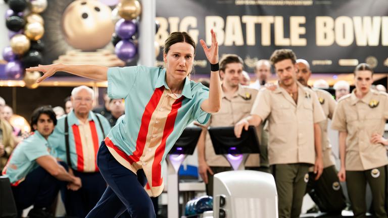 "Die Abräumer": Karo (Bettina Lamprecht) rollt ihre Bowlingkugel mit angespanntem Blick auf die Bowlingbahn.