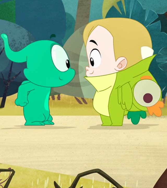 Ernest und Marie-Agnes' kleiner Cousin Basti stehen sich gegenüber. Basti hat ein grünes Drachenkostüm an.