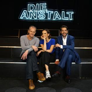 Max Uthoff, Maike Kühl und Claus von Wagner sitzen unter dem Logo von "Die Anstalt".