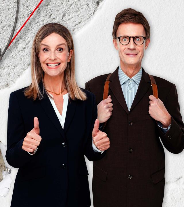 Maike Kühl und Max Uthoff stehen vor einer Collage mit einem Baustellenmotiv. Links im Bild sind zwei rote Baukräne zu sehen und in der Mitte eine große Abrisskugel.