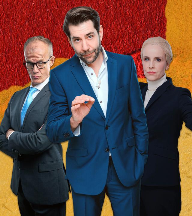 Rechts im Bild stehen Max Uthoff, Claus von Wagner und Maike Kühl vor einem schwarz-rot-goldenen Hintergrund. Links im Bild ist Nico Semsrott mit einer Lupe vor dem Auge hinter einem Pappschild zu sehen. Auf dem Schild befindet sich ein roter Pfeil, der dem Logo der AfD ähnelt, darüber steht das Wort "Prüf".