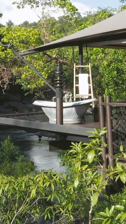 Ein freistehendes Zelt aus Stahlstelzen steht im Regenwald.