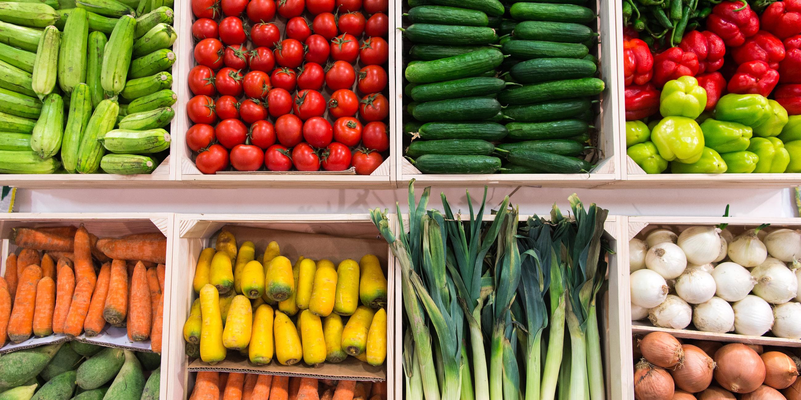 Gurken, Tomaten, Zucchini, Paprika: Diese und verschiedene weitere Gemüsesorten sind in Kisten nebeneinander aufgereiht.