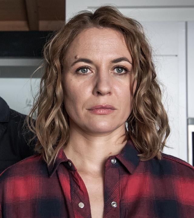 "Der Bergdoktor - Die falsche Frau (2)": Kerstin Rensing (Julia Thurnau) blickt mit ernstem Gesichtsausdruck in die Ferne. Ihr Mann Jakob (Michael Rotschopf) steht mit verlorenem Blick hinter ihr.