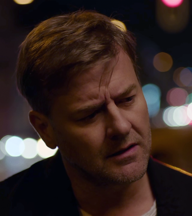 Großaufnahme von Harald Neuhauser (Marcus Mittermeier) nachts auf einer Straße. Er hält den Kopf schräg und schaut nachdenklich. 