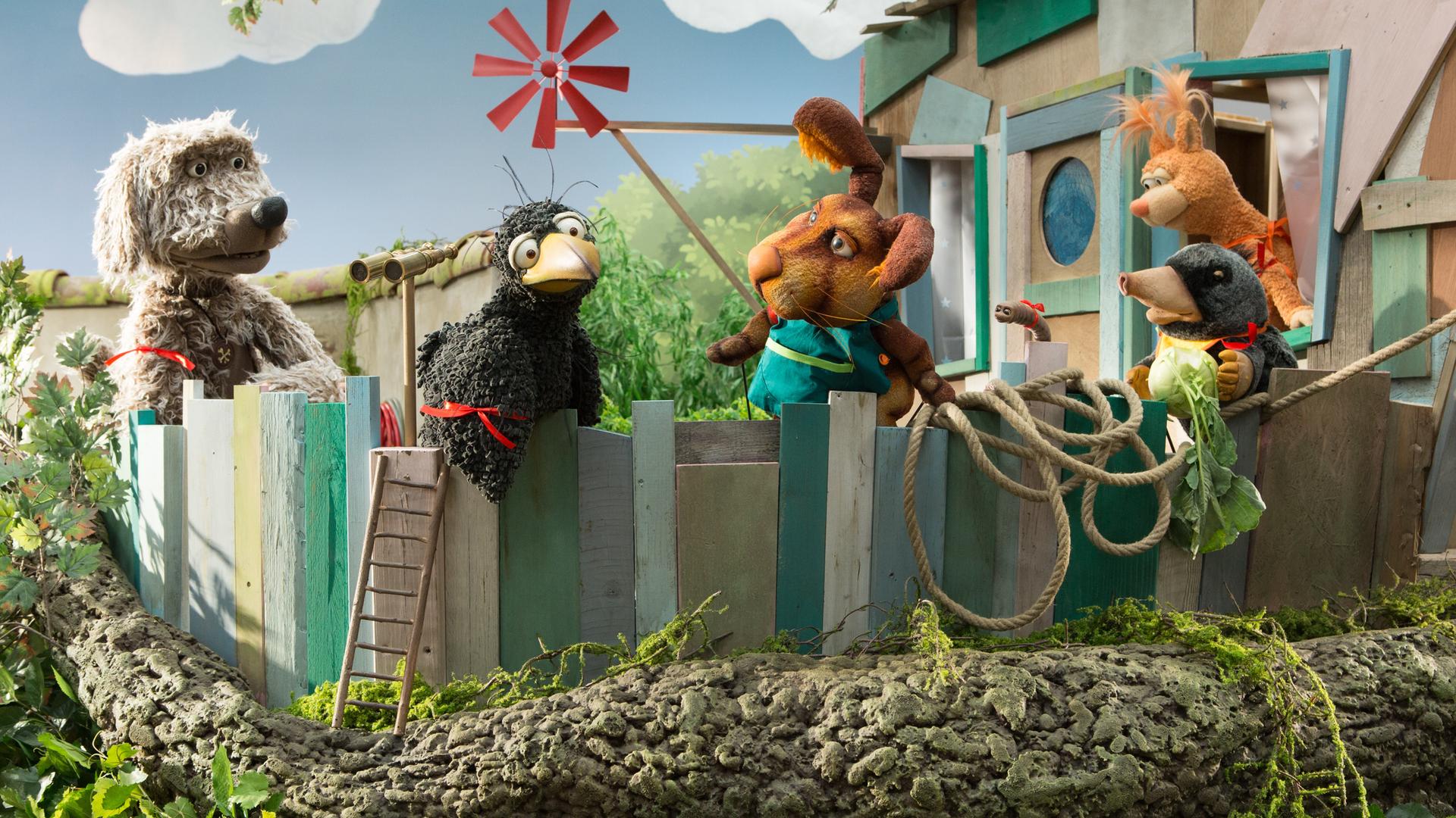 Rudis Rasselbande ist auf der Baumhaus-Veranda versammelt. Alle tragen rote Bändchen. 