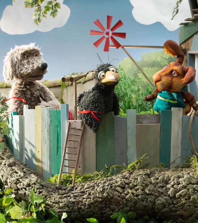 Rudis Rasselbande ist auf der Baumhaus-Veranda versammelt. Alle tragen rote Bändchen. 