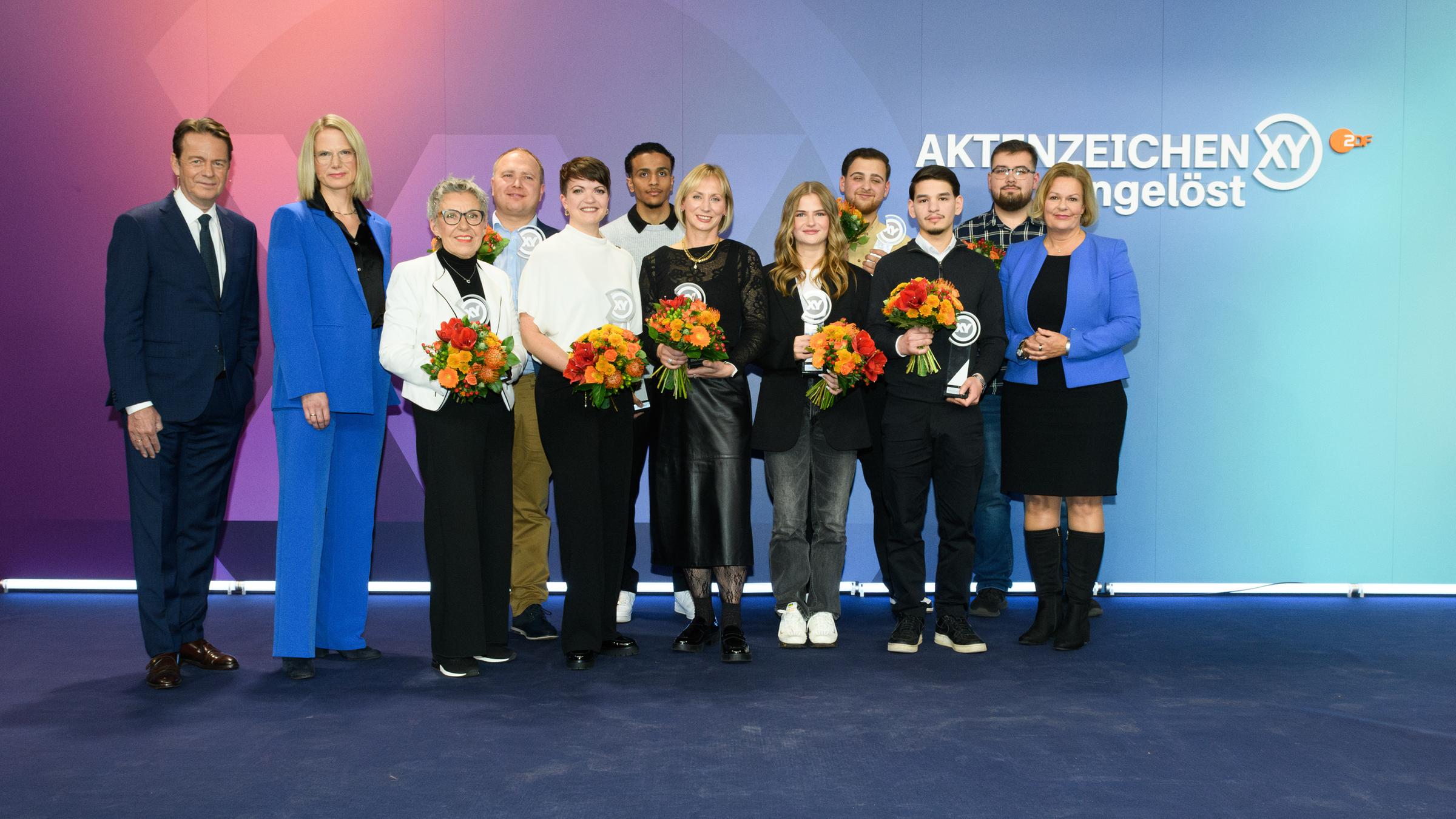 "Die Gewinner des XY-Preises 2024": V.l.n.r.: Rudi Cerne, Dr. Nadine Bilke, Elvira Bunzel, Andreas Bichert, Emma Hufnagel, Amahd Faour, Maika Janat-Vennemann, Kiana Frede, Mohamed Ibrahim, Argjend Klimenta, Leon Jamal Zeid, Bundesinnenministerin Nancy Faeser