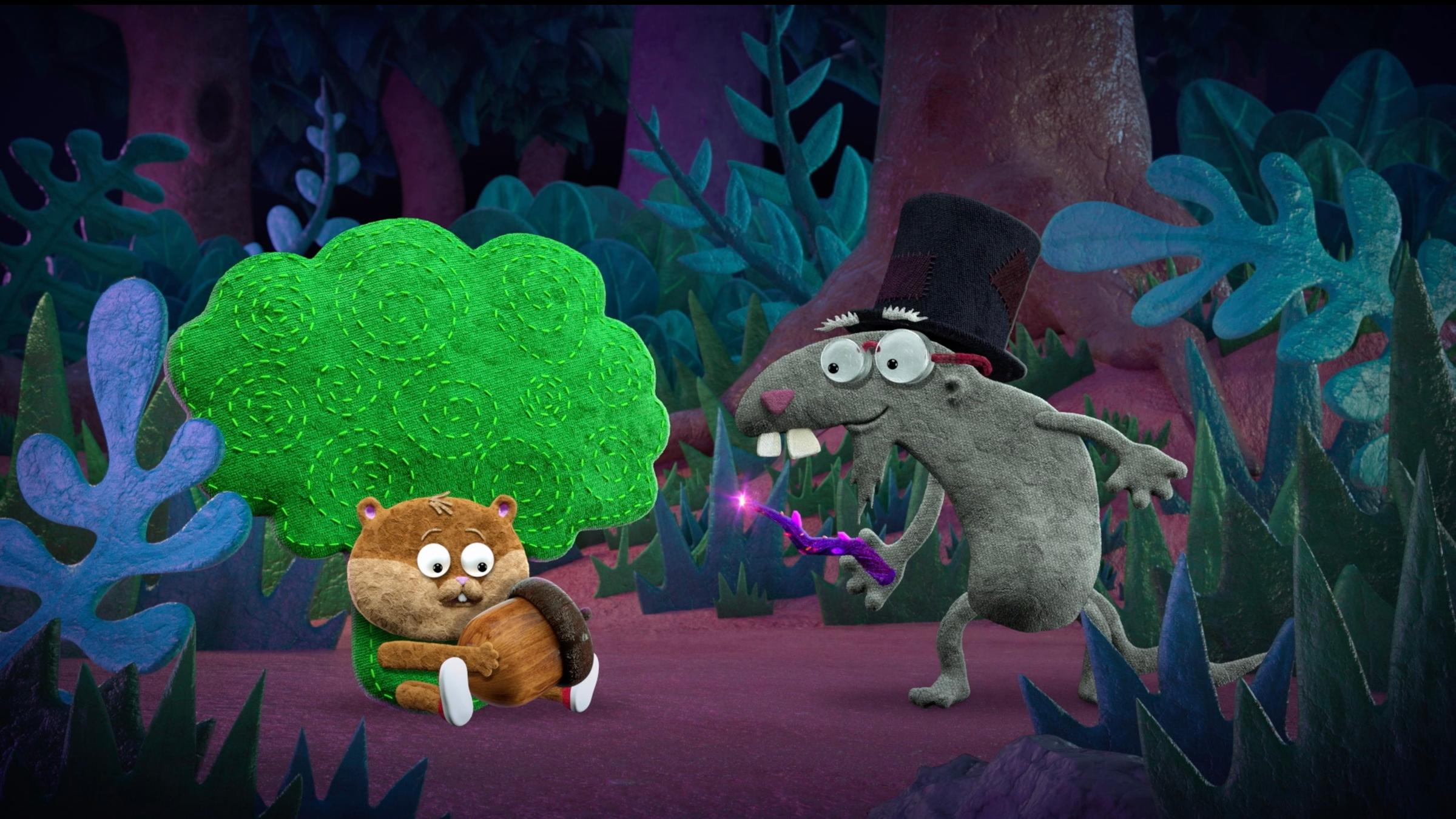 Hamster Rüdiger im Brokkoli-Kostüm sitzt auf dem Boden und hält erstaunt eine Eichel in den Händen. Vor ihm steht Graumüll Frank mit einem leuchtenden Zauberstab in der Hand und schaut Rüdiger erwartungsvoll an.