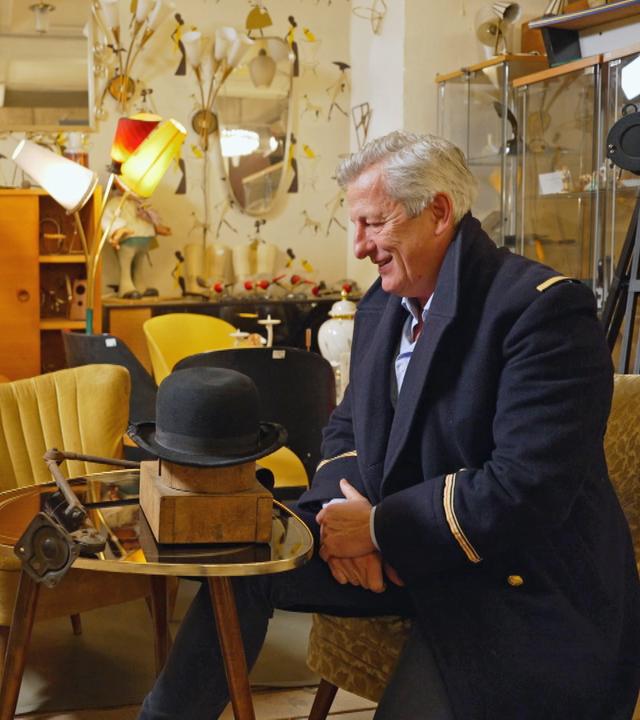 Guido und Markus begutachten einen alten Hutspanner, der zur Lampe umfunktioniert wurde.