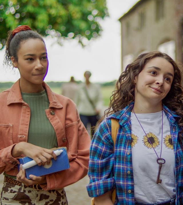 Audrey und Addie verteilen Kerzen im Ort für die als Hexen verurteilten Frauen.