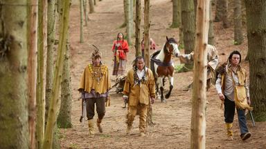 "Die Kanada-Saga - Eigene Wege": Spielszene: Krieger der Plains Cree mit ihrem Anführer "Big Bear" (alle Darsteller unbekannt) laufen durch einen Wald.
