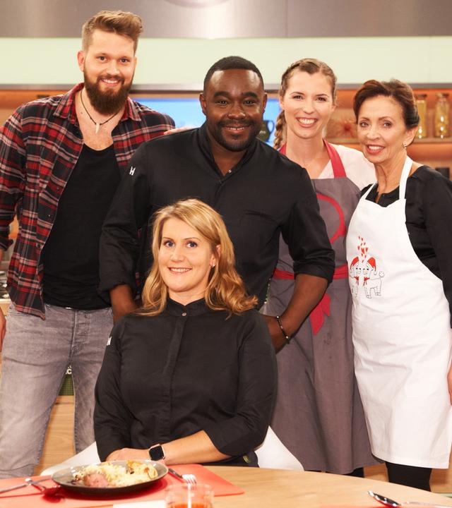 Die Küchenschlacht vom 11. Dezember 2018: Nelson Müller, Julia Kompf und drei Kandidat:innen lächeln in die Kamera.