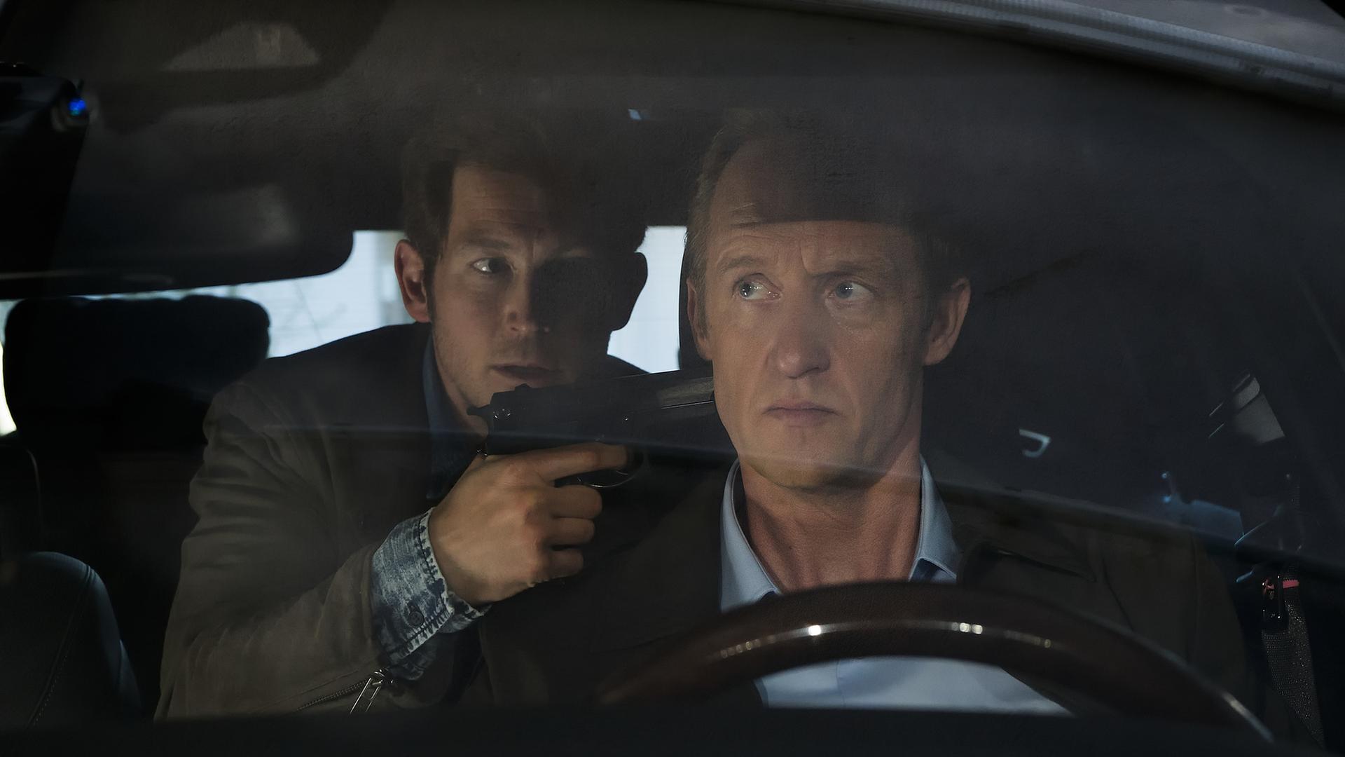 "Die Lebenden und die Toten - Ein Taunuskrimi (2)": Jens-Uwe Hartig (Stefan Murr) bedroht Dr. Simon Burmeister (Stephan Kampwirth) in dessen Auto mit einer Waffe.