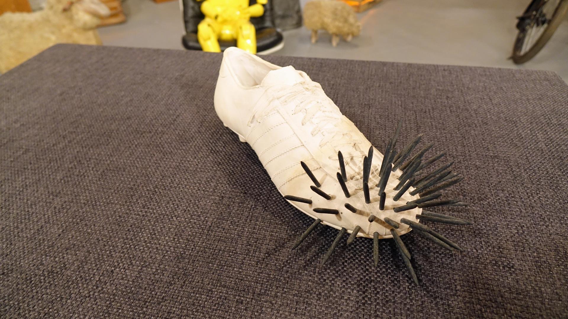 Ein Gipsguss in Form eines Fußballschuhs mit Nägeln von Uecker und Fongi