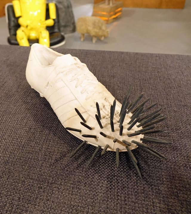 Ein Gipsguss in Form eines Fußballschuhs mit Nägeln von Uecker und Fongi