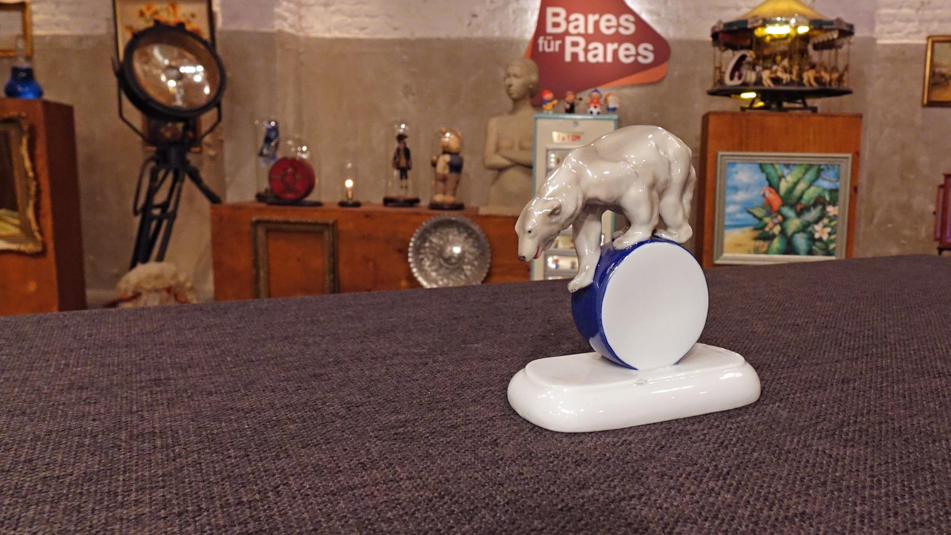 Ein antiker Eisbär aus Porzellan auf einer Rolle.