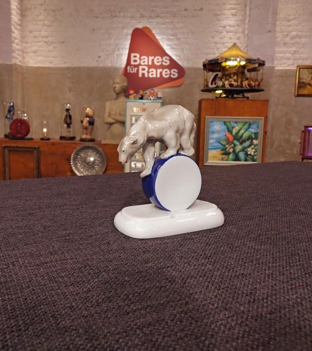 Ein antiker Eisbär aus Porzellan auf einer Rolle.