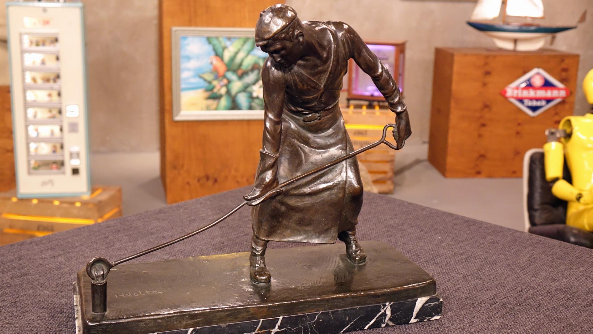 Ein Metallgießer als Bronzefigur