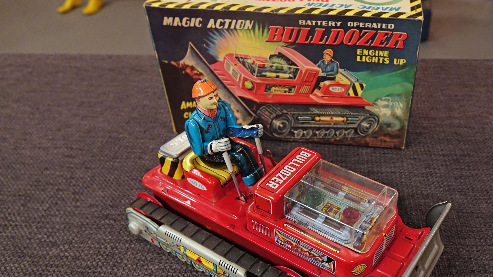 Kleiner, roter Bulldozer mit Fahrer aus Blech und Originalverpackung.
