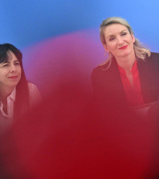 Zwei Frauen lächeln in die Kameras