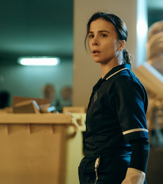 "Serial Cleaner - Die Mission": Teri Marquard (Aylin Tezel) steht in Arbeitskleidung in einem Lagerraum und schaut erstaunt zur Seite.