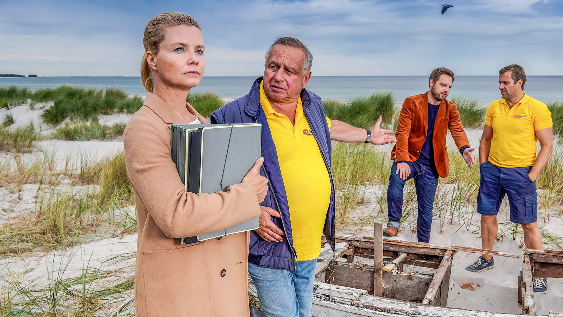 "Ella Schön - Die nackte Wahrheit": Ella steht im Bildvordergrund mit ihrem Klienten Holger Packebusch (Hilmar Eichhorn). Hinten unterhalten sich seine Söhne Maik (Stefan Rudolf) und Kurt (Christoph Letkowski).