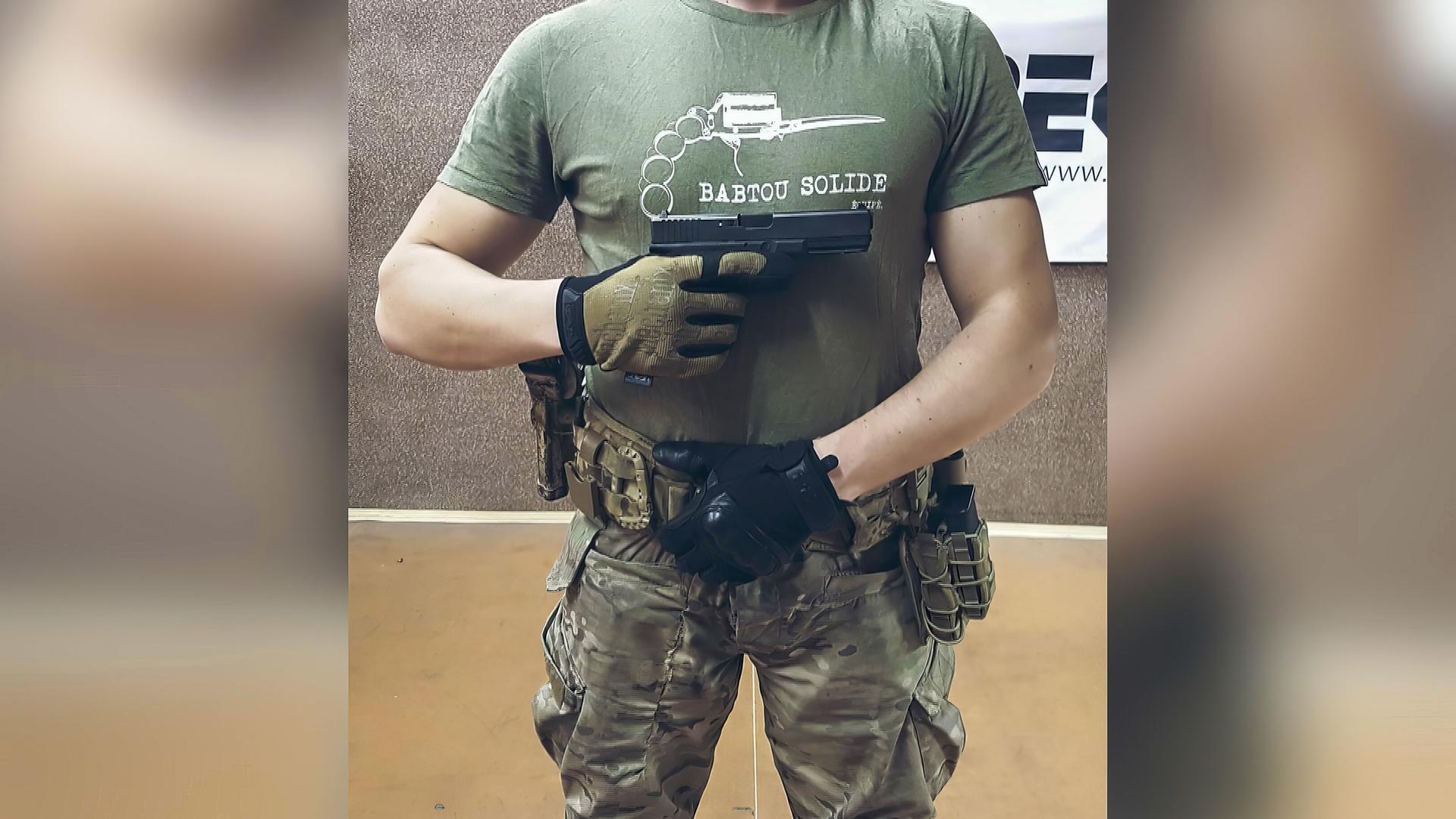 Ein Mann posiert mit Pistole.