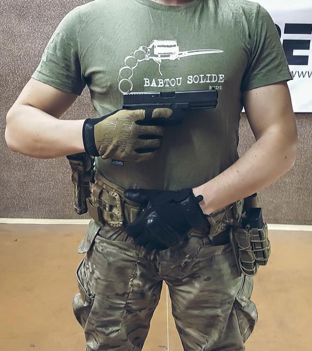 Ein Mann posiert mit Pistole.