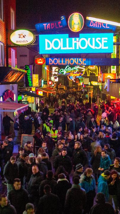 "Die Paten von St. Pauli - Der Aufstieg von Wilfrid Schulz": Leuchtreklamen auf der Reeperbahn, Hamburg St. Pauli bei Nacht mit Besuchern.